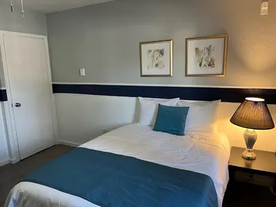 a bedroom with a blue and white bed with a lamp at Celadon Lodge in Radium Hot Springs