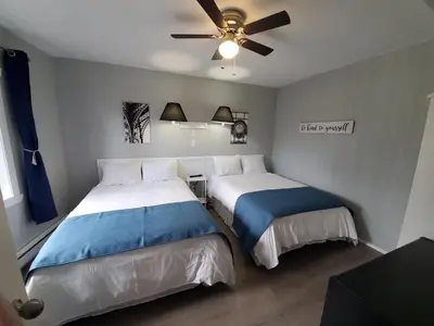 a bedroom with two beds and a ceiling fan at Celadon Lodge in Radium Hot Springs