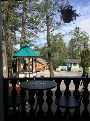 a table with two wine glasses on a porch at Celadon Lodge in Radium Hot Springs