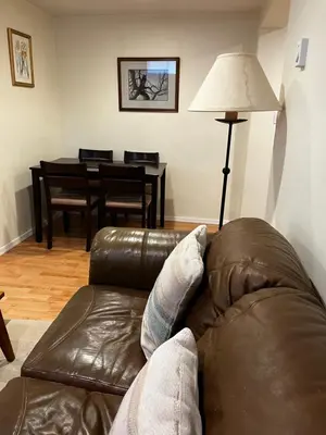a living room with a brown leather couch and a table at Revelstoke Long Term in Revelstoke