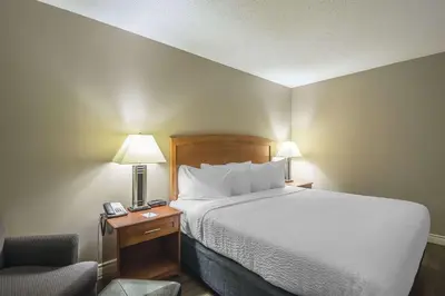 a bedroom with a bed and a desk with a chair at Quality Inn West Edmonton in Edmonton