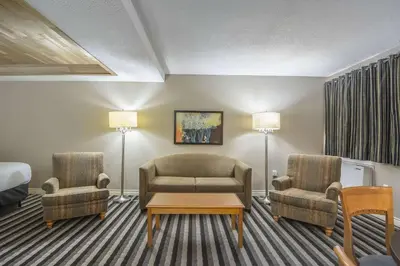 a hotel room with a couch and chairs and a bed at Quality Inn West Edmonton in Edmonton
