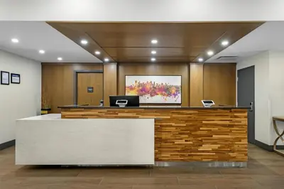 an office with a reception desk with a painting on the wall at Best Western Plus Suites Downtown Calgary in Calgary