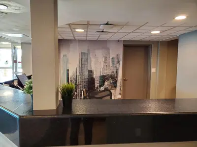 an office with a wall mural of a city at Super 8 by Wyndham Macleod Trail Calgary in Calgary