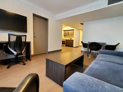 a living room with a couch and a table and chairs at Super 8 by Wyndham Macleod Trail Calgary in Calgary