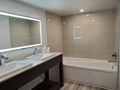a bathroom with two sinks and a tub and a mirror at Super 8 by Wyndham Macleod Trail Calgary in Calgary