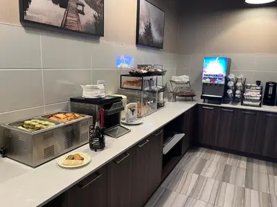 a kitchen with a counter with food on it at Super 8 by Wyndham Macleod Trail Calgary in Calgary
