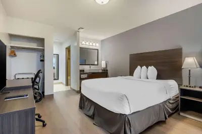 a hotel room with a large bed and a desk at Super 8 by Wyndham Macleod Trail Calgary in Calgary