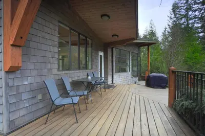 a deck with chairs and a table on a house at The Perch at Moon Dance in Garden Bay