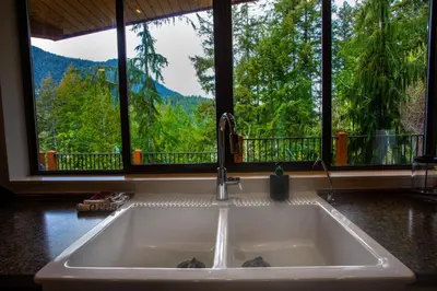 a kitchen sink in front of a window with a view at The Perch at Moon Dance in Garden Bay