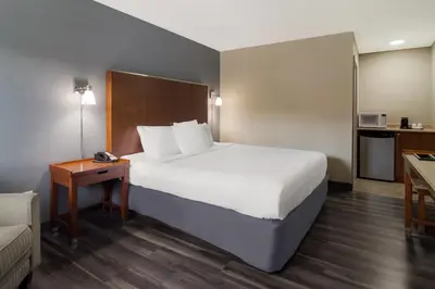 a hotel room with a large bed and a couch at Canadas Best Value Inn & Suites Kamloops in Kamloops