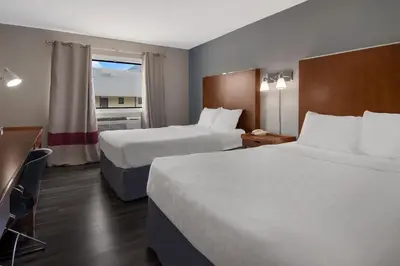 a hotel room with two beds and a window at Canadas Best Value Inn & Suites Kamloops in Kamloops