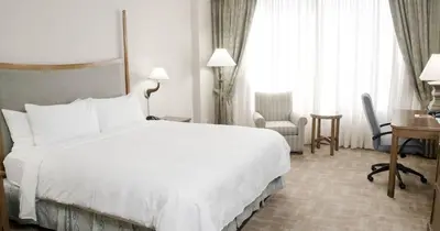 a hotel room with a large white bed and a desk at River Cree Resort & Casino in Edmonton