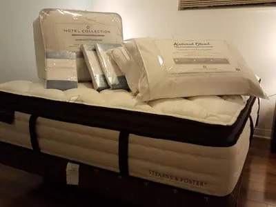 a mattress with two boxes on top of it at Emperial Suites in North Vancouver