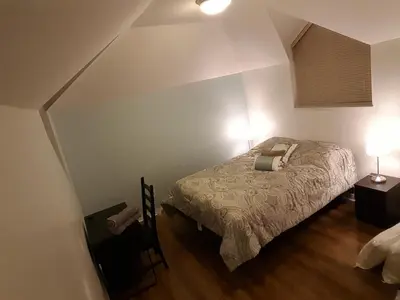 a bedroom with a bed and two lights on at Emperial Suites in North Vancouver