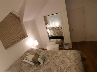 a bedroom with a bed and a large mirror at Emperial Suites in North Vancouver