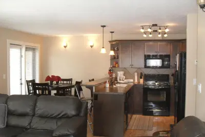a kitchen and living room with a couch and a table at Mountain View Radium Condo - Copper Horn Village in Radium Hot Springs