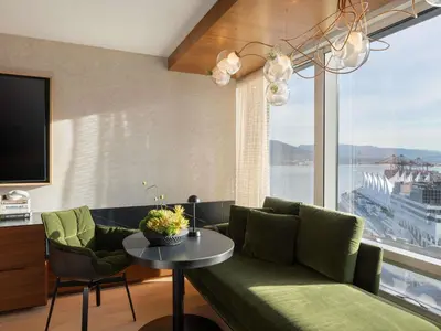 a living room with a green couch and a table at Fairmont Pacific Rim in Vancouver