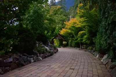 a brick road in a park with trees at The Lodge on Harrison Lake in Harrison Hot Springs