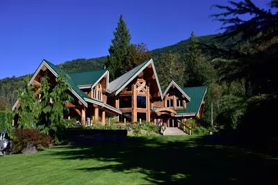 a large wooden house with a green roof at The Rockwell-Harrison Guest Lodge in Harrison Hot Springs