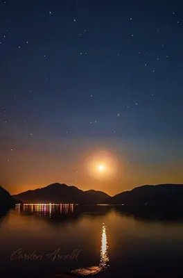 a view of a lake at night with the sun at The Rockwell-Harrison Guest Lodge in Harrison Hot Springs