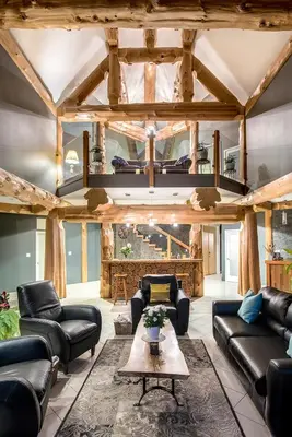 a living room with leather couches and a table at The Rockwell-Harrison Guest Lodge in Harrison Hot Springs