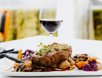 a plate of food and a glass of wine at Hotel Eldorado at Eldorado Resort in Kelowna