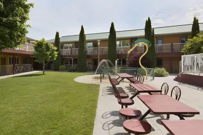 a group of picnic tables and chairs in a courtyard at Days Inn by Wyndham Penticton Conference Centre in Penticton