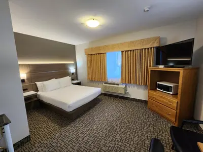 a hotel room with a bed and a television at Days Inn by Wyndham Penticton Conference Centre in Penticton