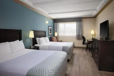 a hotel room with two beds and a flat screen tv at Best Western Plus Kamloops Hotel in Kamloops