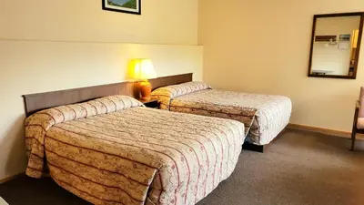 a hotel room with two beds and a lamp at Sea Raven Motel in Queen Charlotte