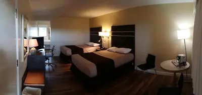 a hotel room with two beds and a table at Bear Country Inn in Terrace