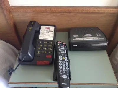 a group of remote controls sitting on a shelf at The Ranchland Inn Kamloops in Kamloops