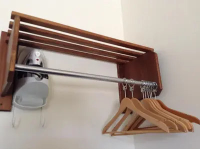 a wooden rack with wooden hangers on a wall at The Ranchland Inn Kamloops in Kamloops