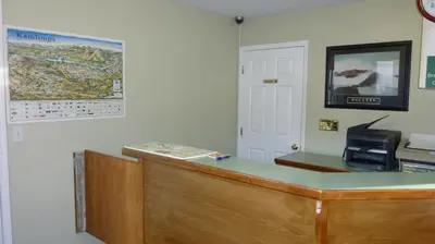 a reception desk in a office with a map on the wall at The Ranchland Inn Kamloops in Kamloops