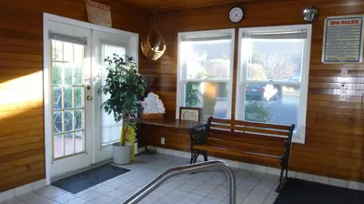 a bench sitting in the corner of a building with windows at The Ranchland Inn Kamloops in Kamloops