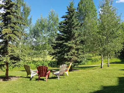 a group of chairs sitting in the grass at Sunset Mountain Inn in Canmore