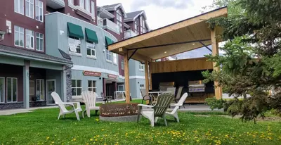 a group of chairs sitting on the grass in a yard at Sunset Mountain Inn in Canmore