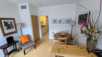 a living room with a table and a dining room at Sunset Mountain Inn in Canmore
