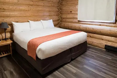 a bedroom with a bed in a log cabin at Glacier House Hotel & Resort in Revelstoke