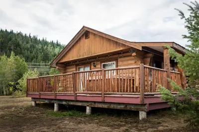 a log cabin with a large deck at Glacier House Hotel & Resort in Revelstoke