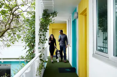 a man and a woman walking a dog down a hallway at The Burrard in Vancouver
