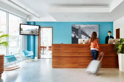 a woman walking past a counter in an office at The Burrard in Vancouver