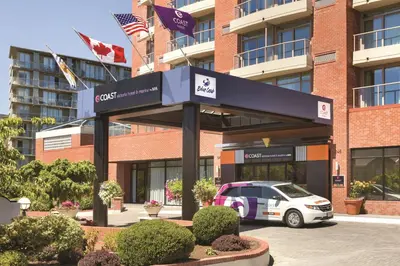a car parked in a parking lot in front of a building at Coast Victoria Hotel & Marina by APA in Victoria