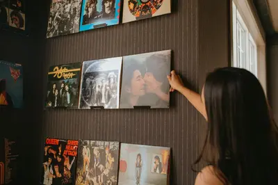 a woman is looking at movies on a wall at Creekside Villa in Canmore