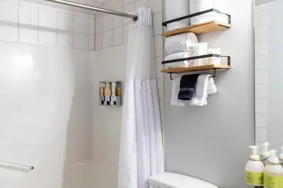 a bathroom with a shower and a white shower curtain at Creekside Villa in Canmore