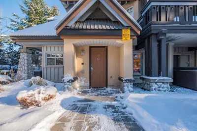 a house with a brown door in the snow at Lagoons by Outpost Whistler in Whistler