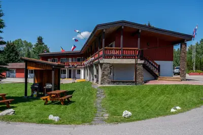 a building with a picnic table and benches in front of it at Rocky Mountain Ski Lodge in Canmore