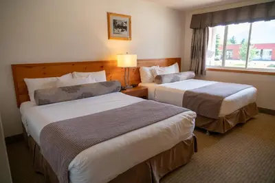 a hotel room with two beds and a window at Rocky Mountain Ski Lodge in Canmore