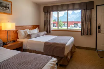 a hotel room with two beds and a window at Rocky Mountain Ski Lodge in Canmore